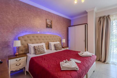 a bedroom with a large bed with a red bedspread at Knights' Castle Studios in Archangelos