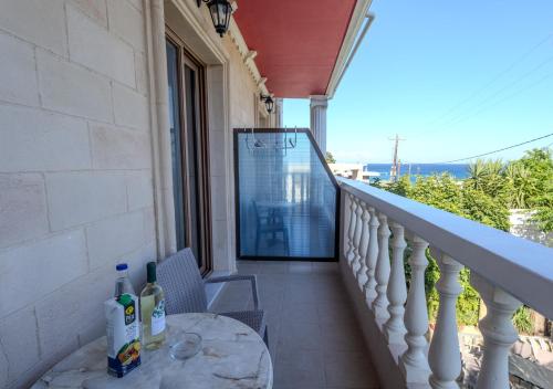 a balcony of a house with a table and a window at Knights' Castle Studios in Archangelos