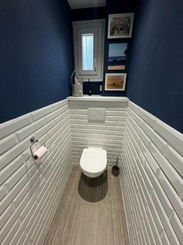 La salle de bains est pourvue de toilettes blanches dans un mur bleu. dans l'établissement Appartement Spacieux à Bron - 30' Groupama Stadium, à Bron