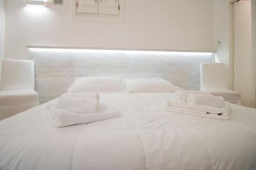 a white bed with white towels on top of it at Sui Tetti Luxury Rooms in Lecce