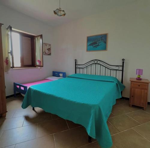 a bedroom with a bed with a blue comforter at Residence i tre mulini in Garigliano