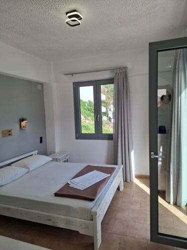 a bedroom with a bed and a window at Ostria in Agia Galini