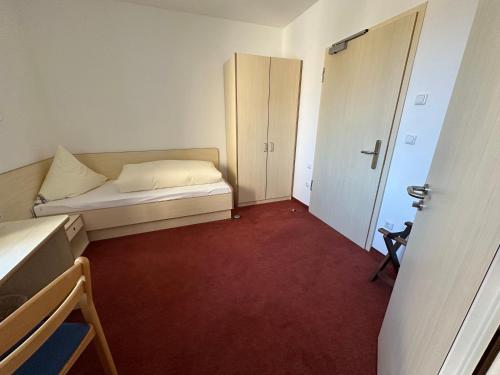 a small room with a bed and a door at GER-Haus in Waischenfeld