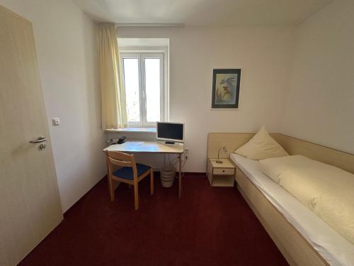 a bedroom with a bed and a desk with a computer at GER-Haus in Waischenfeld