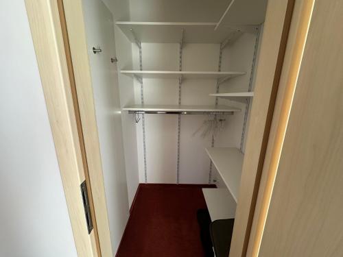 an empty closet with white shelves in a room at GER-Haus in Waischenfeld