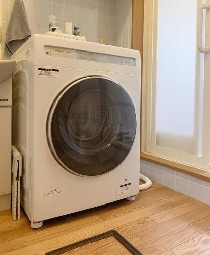 a white washing machine sitting in a kitchen at Perfect for families Spacious 4bedrooms Washer-dryer Car Free Parking ファミリーに最適 4LDK 洗濯乾燥機 駐車場無料 in Osaka