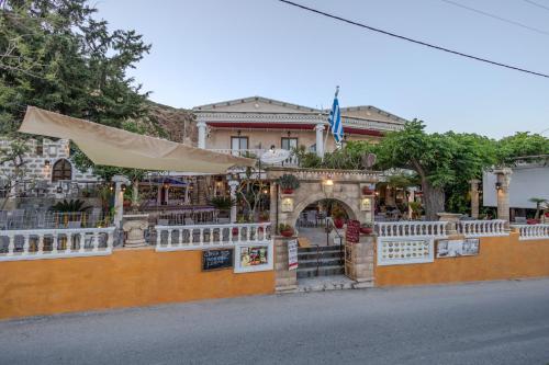 a building with a white fence in front of it at Knights' Castle Studios in Archangelos