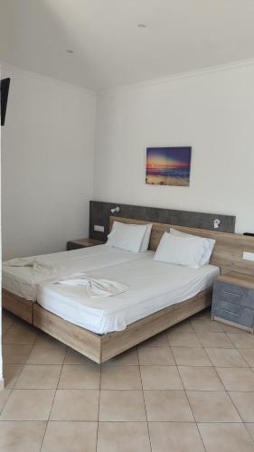 a bedroom with a large bed with white sheets at Smaragda Hotel in Marathokampos