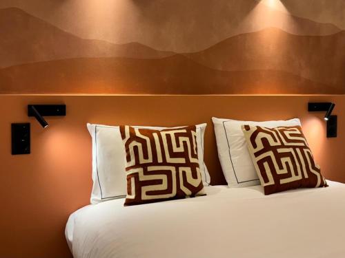 a bedroom with a bed with two pillows on it at Hôtel Etoile Trocadéro in Paris