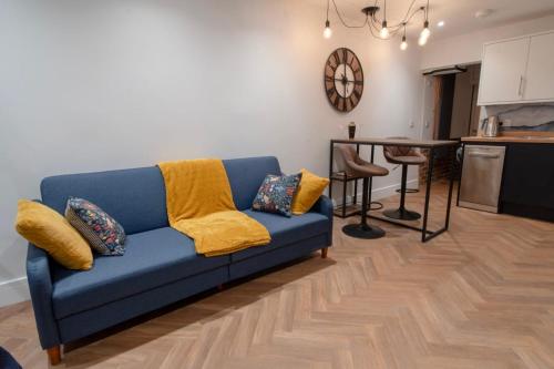 a blue couch in a living room with a kitchen at Hidden Home in Haywards Heath