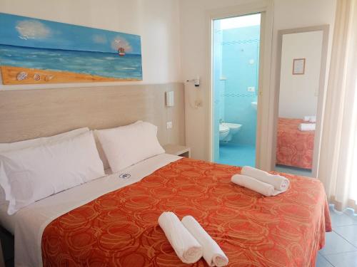 a bedroom with a bed with two towels on it at Hotel Adriana in Bellaria-Igea Marina
