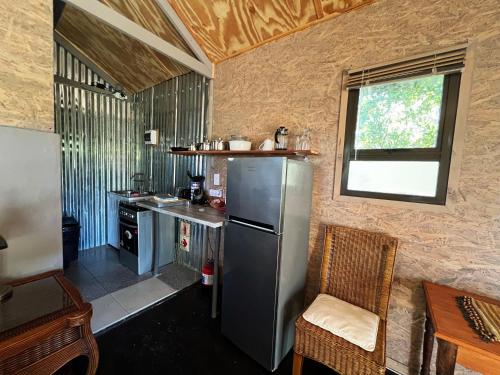 a kitchen with a stainless steel refrigerator and a window at Tenikwa Wildlife Centre & Spa in Plettenberg Bay