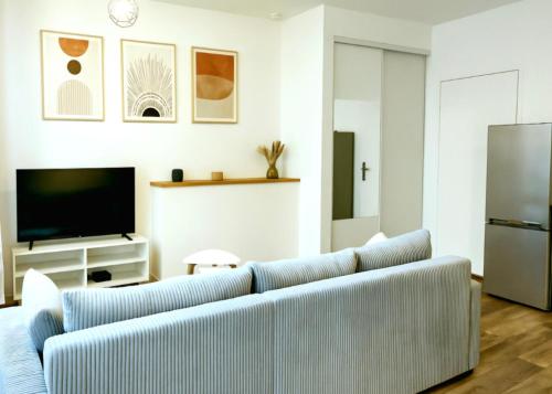 un salon avec un canapé et une télévision dans l'établissement Logement proche Hypercentre CAEN, à Caen