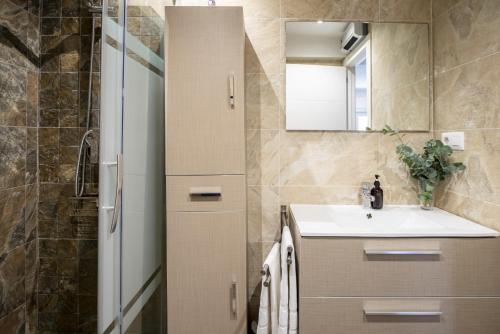 un baño con lavabo y espejo en Apartment Atalaya in the center, en Santander