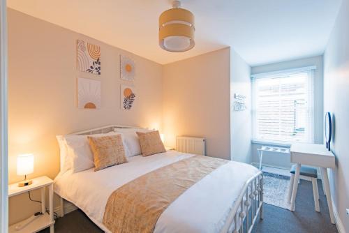 a bedroom with a bed and a desk and a window at Strand Apartment by Keepers Cottages in Deal