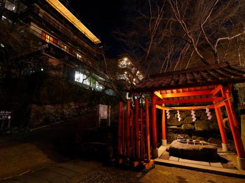 a small shrine with a red gate at night at 多武峰観光ホテル in Sakurai