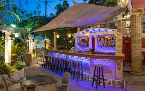 a bar at a restaurant with purple lighting at Knights' Castle Studios in Archangelos