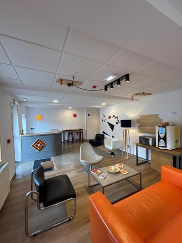 a living room with an orange couch and chairs at Lotila Flats Rio Caudal in Figaredo