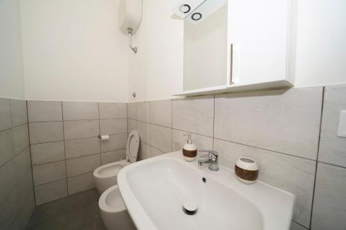 a white bathroom with a sink and a toilet at Da Piero e Gina in Palidoro