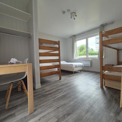 une chambre avec deux lits superposés et un bureau dans l'établissement Centre de Vacances CPCV Normandie à 50 metres de la plage de Houlgate, à Houlgate