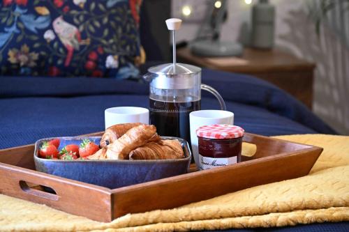a tray of food with a bowl of bread and fruit at Hidden Home in Haywards Heath