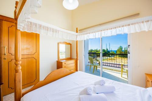 a bedroom with a bed and a large window at Villa Christina in Argaka