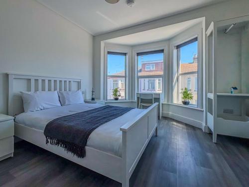 a white bedroom with a large bed and windows at Nelson Road North in Great Yarmouth