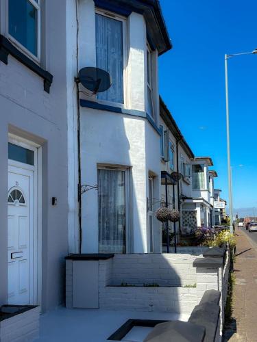 a white building with stairs and a door on a street at Nelson Road North in Great Yarmouth