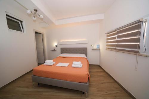 a bedroom with a bed with orange sheets and a window at Da Piero e Gina in Palidoro