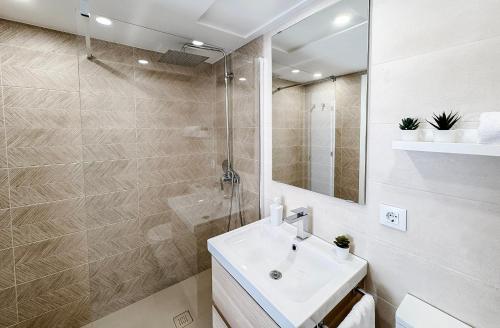 a bathroom with a sink and a shower and a mirror at NUEVO, a 70 metros de la playa y con vistas al mar in Cullera