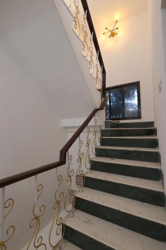 a staircase with black and gold railings at Gorai Villa - Gagal Home in Mumbai