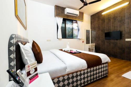 a hotel room with a bed and a television at Gorai Villa - Gagal Home in Mumbai