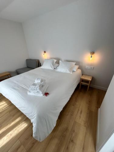 a bedroom with a large white bed with white sheets at Pensión do Catro in Puebla de Trives