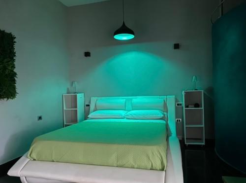 a bedroom with a bed with a blue light at Suite House in Sora
