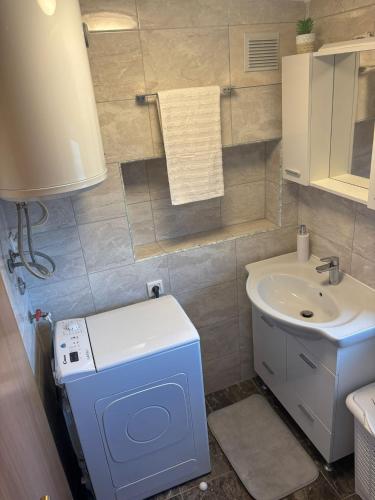 a bathroom with a sink and a washing machine at Apartment & Studio Vrdoljak in Sveti Anton