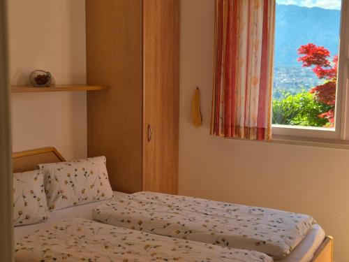 a small bedroom with a bed with a window at Apartmenthaus am Waalweg in Caines
