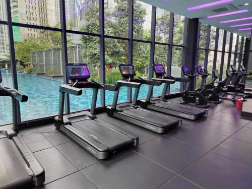 a row of treadmills in a gym with a pool at KLCC by Star Residences in Kuala Lumpur