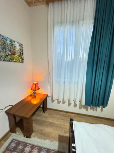 a bedroom with a table in front of a window at Odo’s Guest House in Martvili