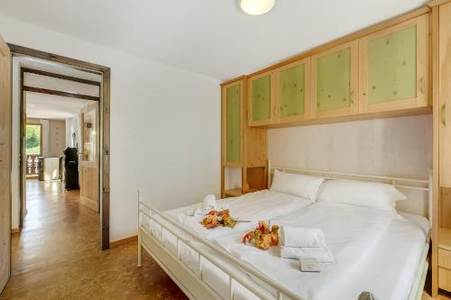 a bedroom with a large white bed with wooden cabinets at Casa Andy 2 Val Lavizzara - Happy Rentals in Al Piano