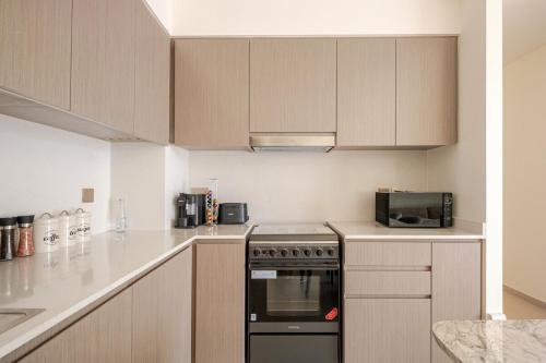 a kitchen with a stove and a microwave at Luxury 2BR Burj Khalifa & Dubai Mall Fountain View in Dubai