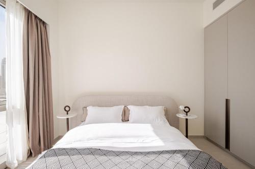 a bedroom with a bed with white sheets and pillows at Luxury 2BR Burj Khalifa & Dubai Mall Fountain View in Dubai