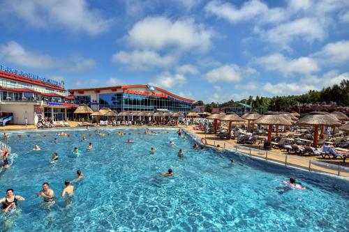 a group of people swimming in a swimming pool at Willa Biały Dom - Aquapark Panorama Morska All Inclusive in Jarosławiec