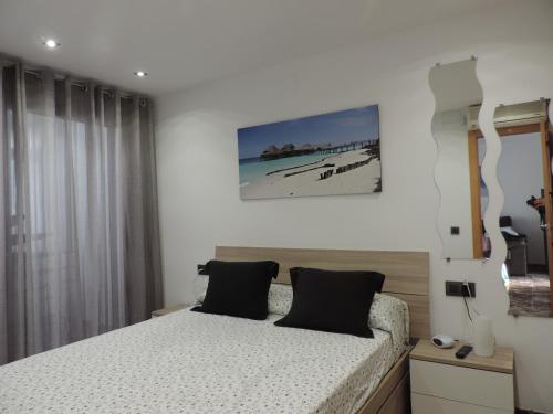 1 dormitorio con 1 cama y una foto de playa en Apartments Varadero, en Salou