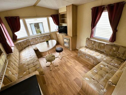 a living room with a couch and a table at Alex Domki Angielskie Taras Widokowy in Rewal