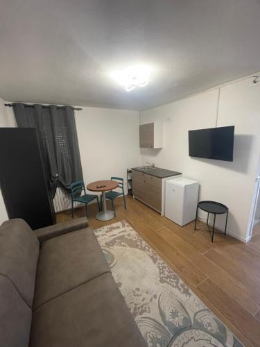 a living room with a couch and a table and a kitchen at L&L Bed and Breakfast Malpensa Airport in Samarate