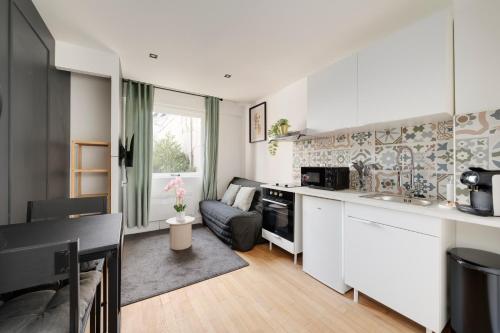 une cuisine et un salon avec un canapé dans une pièce dans l'établissement L'Ecrin de Jennesson - Studio 2 Pers - Nancy, à Nancy