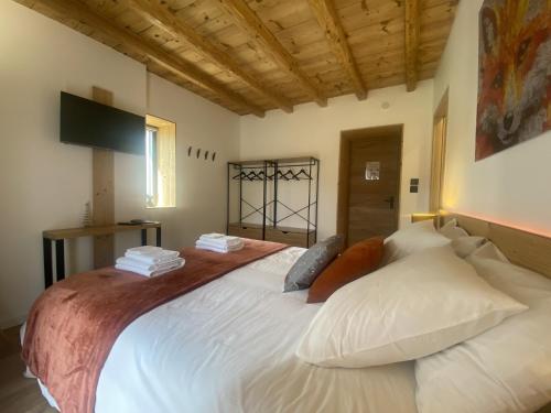 a bedroom with a large white bed with pillows at Du Côté de Chez Sou in Arâches-la-Frasse