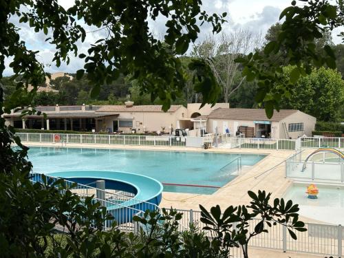 une grande piscine avec un bâtiment en arrière-plan dans l'établissement Domaine de la Coudouliere - Studio, à Six-Fours-les-Plages