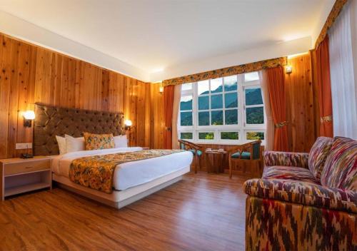 a bedroom with a bed and a couch at Summit Gangchen Hotel in Lachen