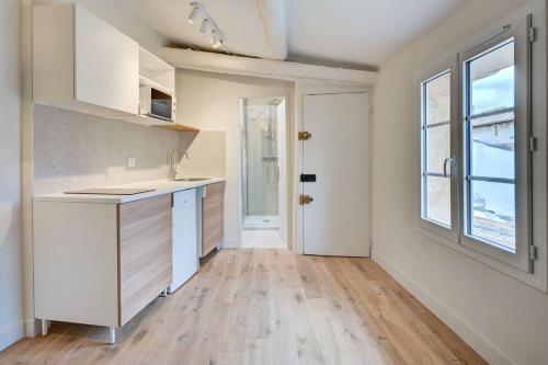 une cuisine vide avec un évier et une fenêtre dans l'établissement New! Le zola studio lumineux en centre ville, à Aix-en-Provence
